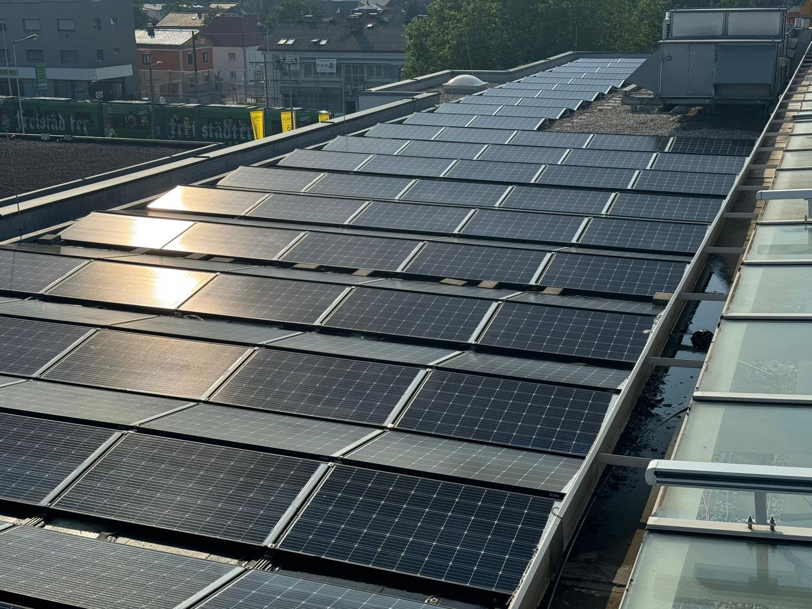 Große Photovoltaikanlage auf einem Flachdach mit Reihen von Solarmodulen in der Sonne