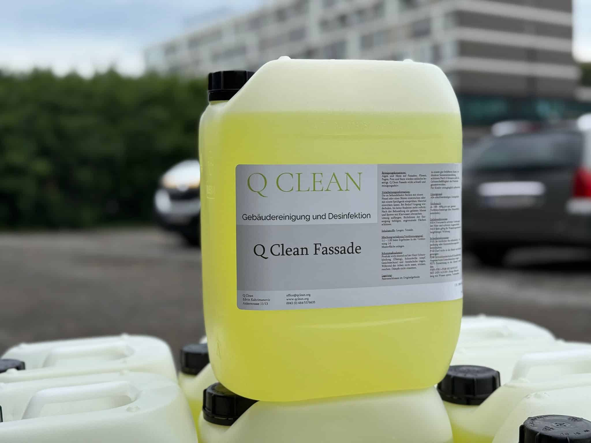 Gelber Q Clean Fassadenreiniger Kanister in Nahaufnahme, weitere Kanister im Hintergrund gestapelt